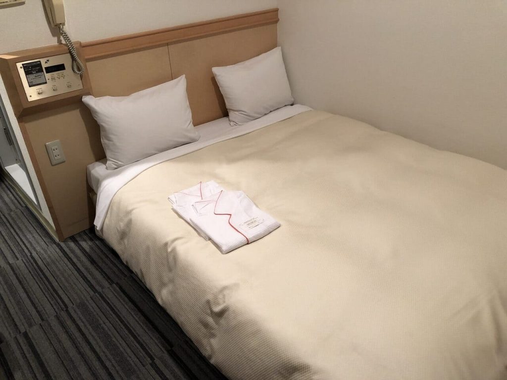 Cama de la habitación del Premier Hotel Cabin Matsumoto